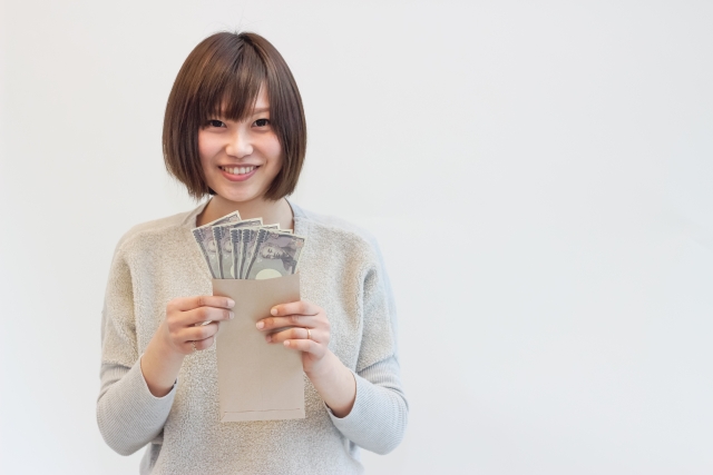 お金をもって微笑む若い日本人女性